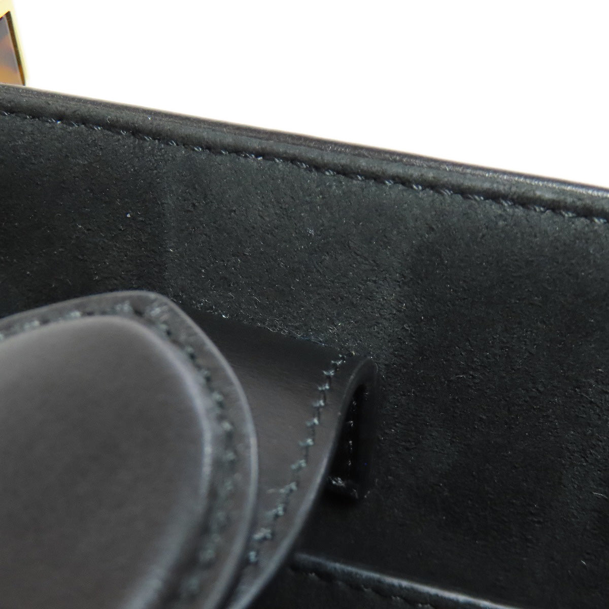 Close-up of a black leather product with stitching detail