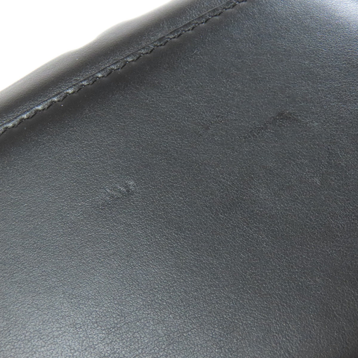 Close-up of dark gray leather surface with visible stitching