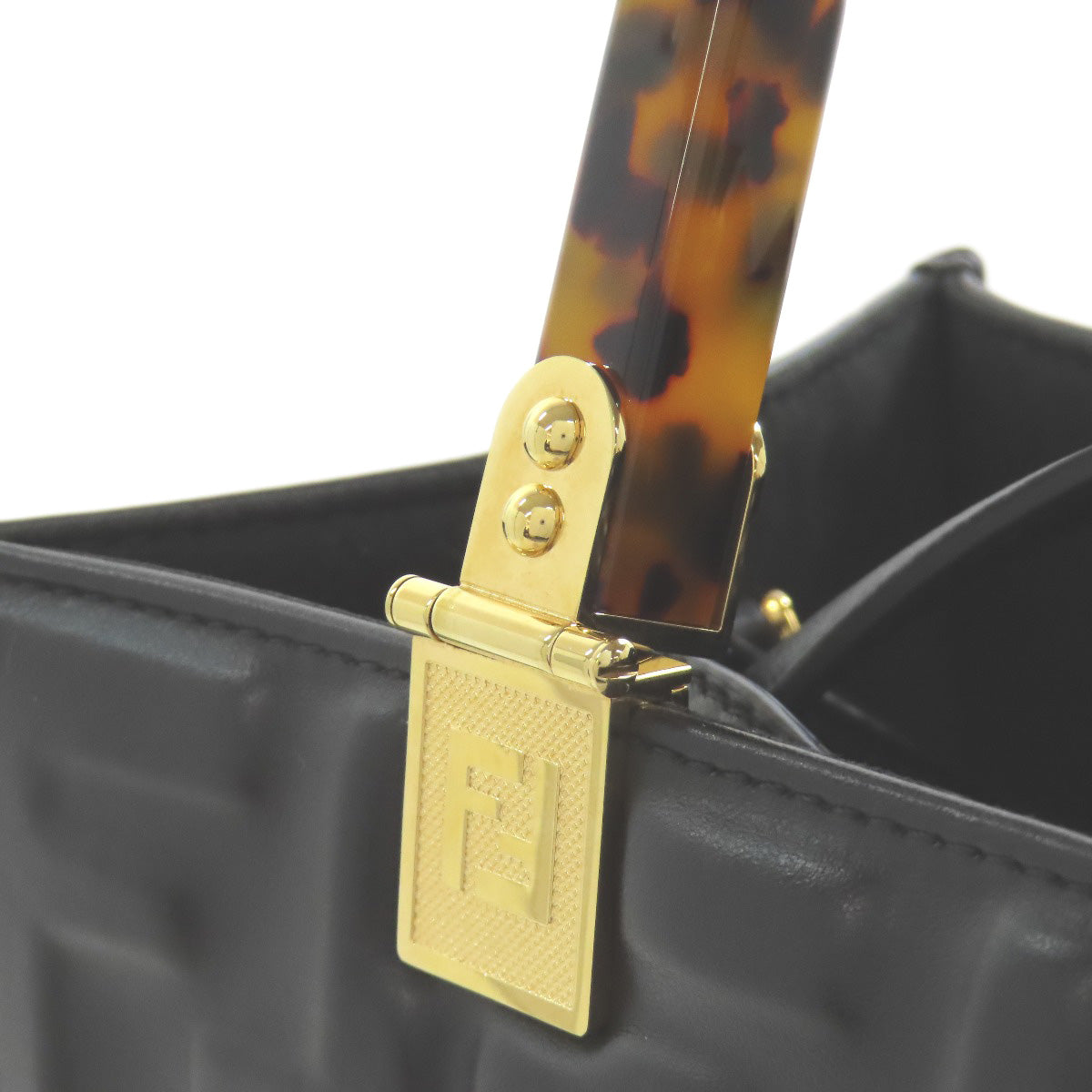 Black handbag with gold clasp and tortoiseshell handle on a white background