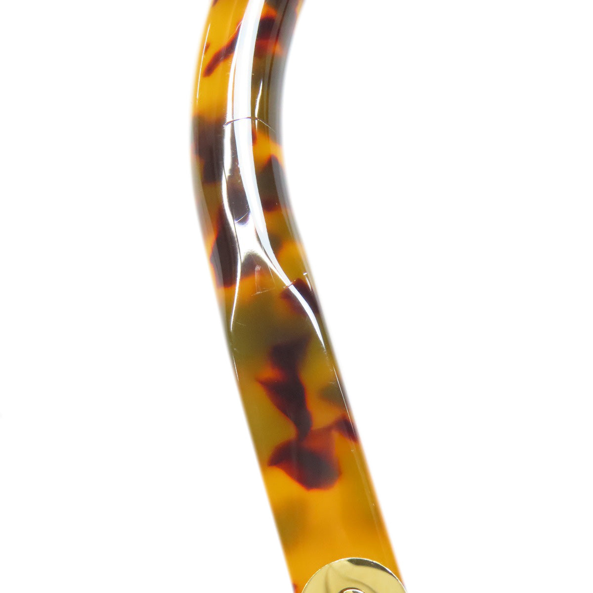 Tortoiseshell-patterned handle with gold accent on a white background