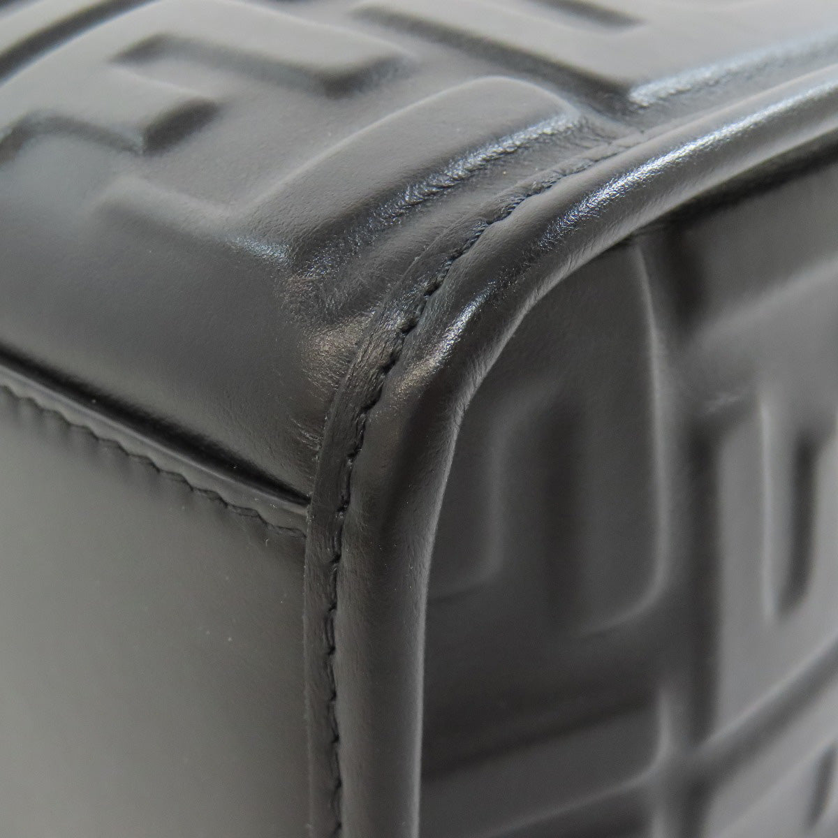 Close-up of a textured gray surface with a focus on the corner and stitching detail.