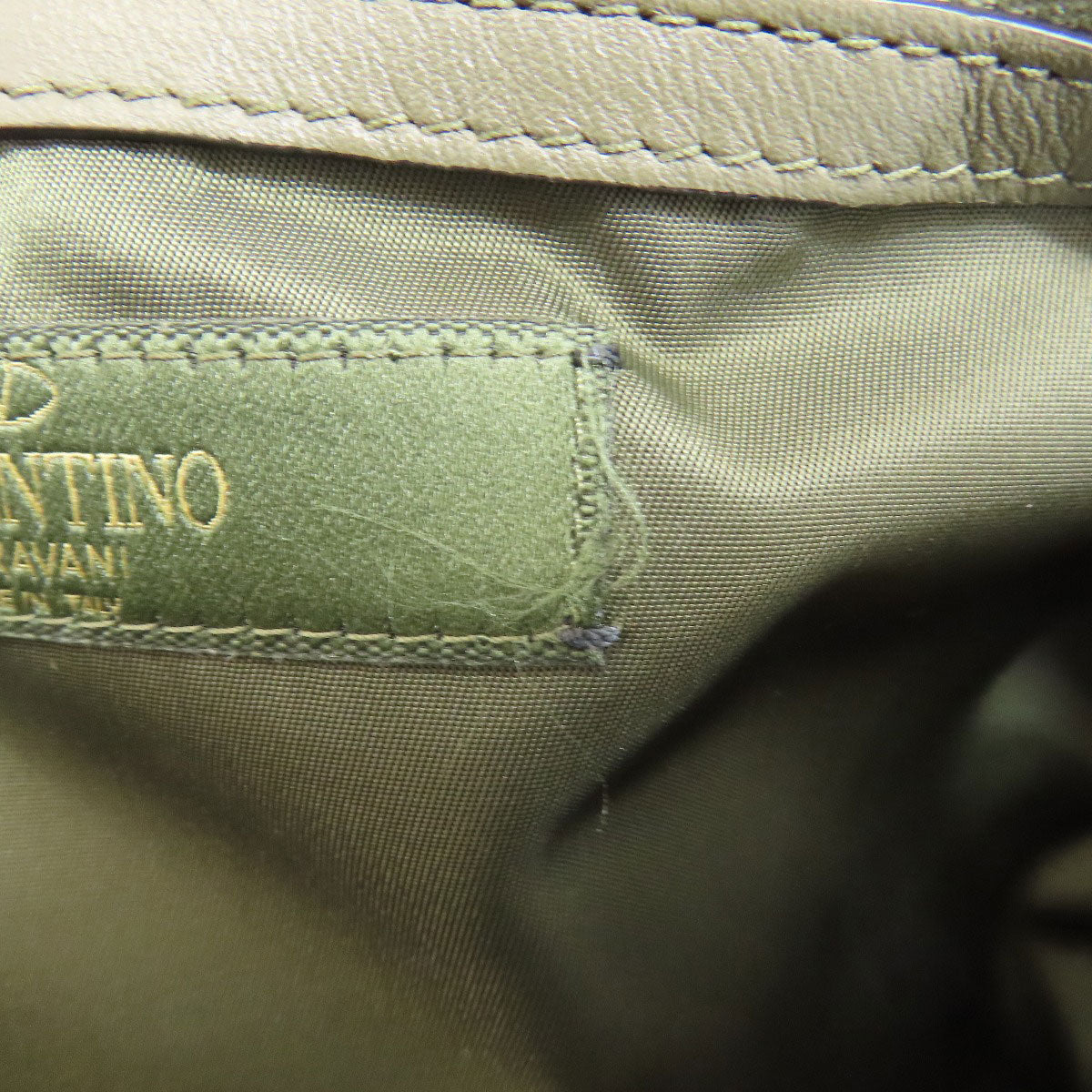 Close-up of a green fabric label on a piece of green fabric.