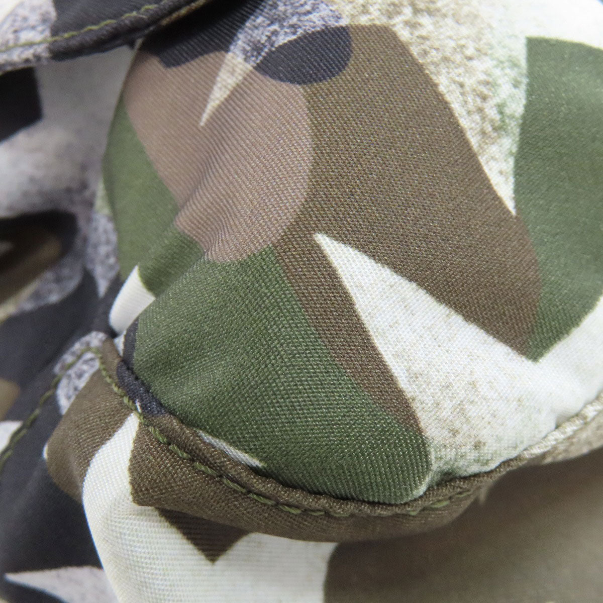 Close-up of a camouflage-patterned fabric with a focus on texture and color.