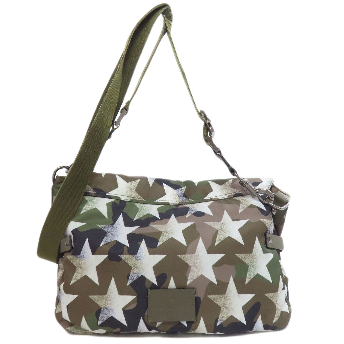 Handbag with star pattern and green strap on a white background