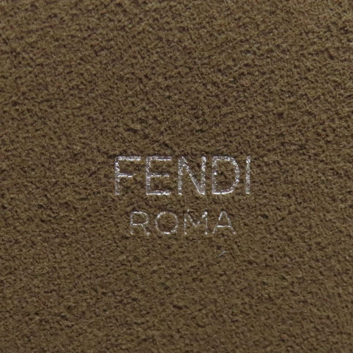 Fendi logo embossed on a brown textured surface