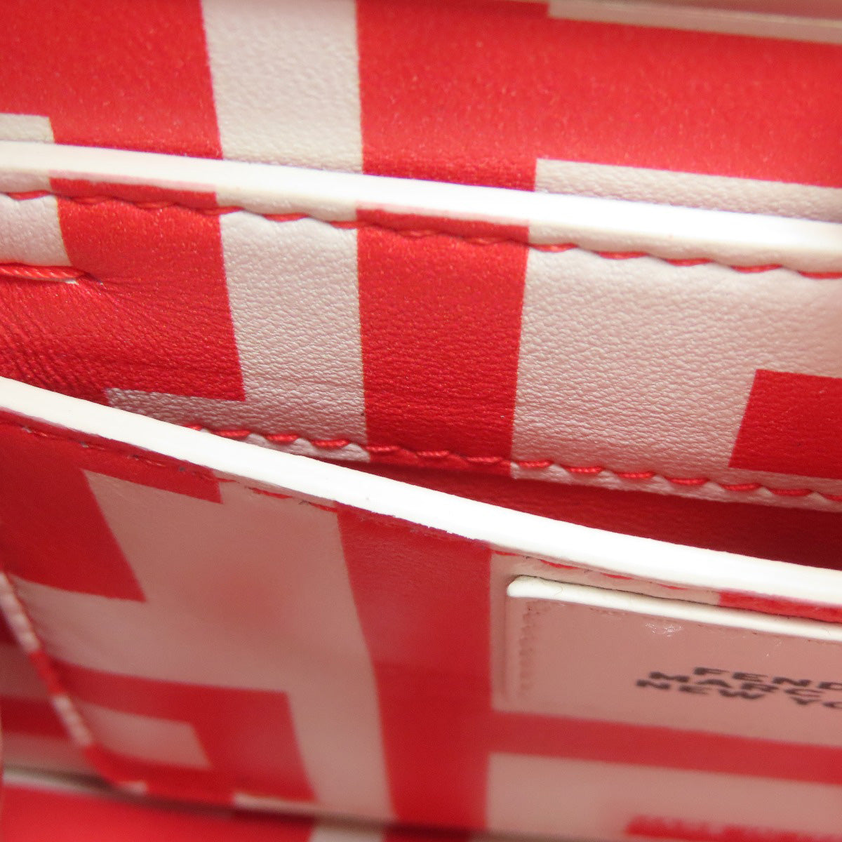 Close-up of a red and white patterned fabric with a visible brand label.