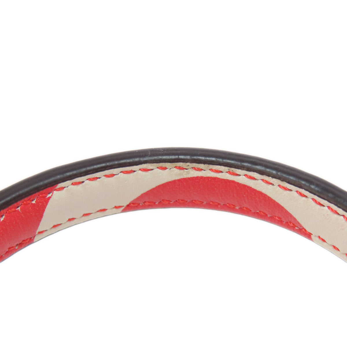 Close-up of a belt with red and beige pattern on a white background