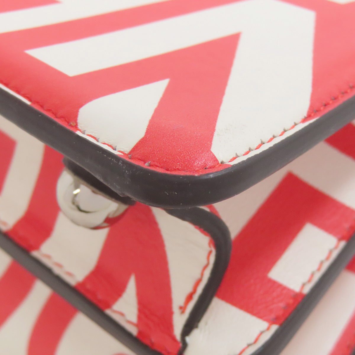 Close-up of a red and white zigzag patterned product with a black border.