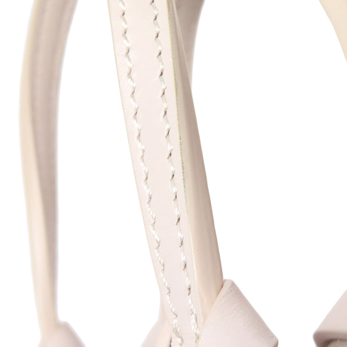 Close-up of a beige leather strap with stitching detail on a white background