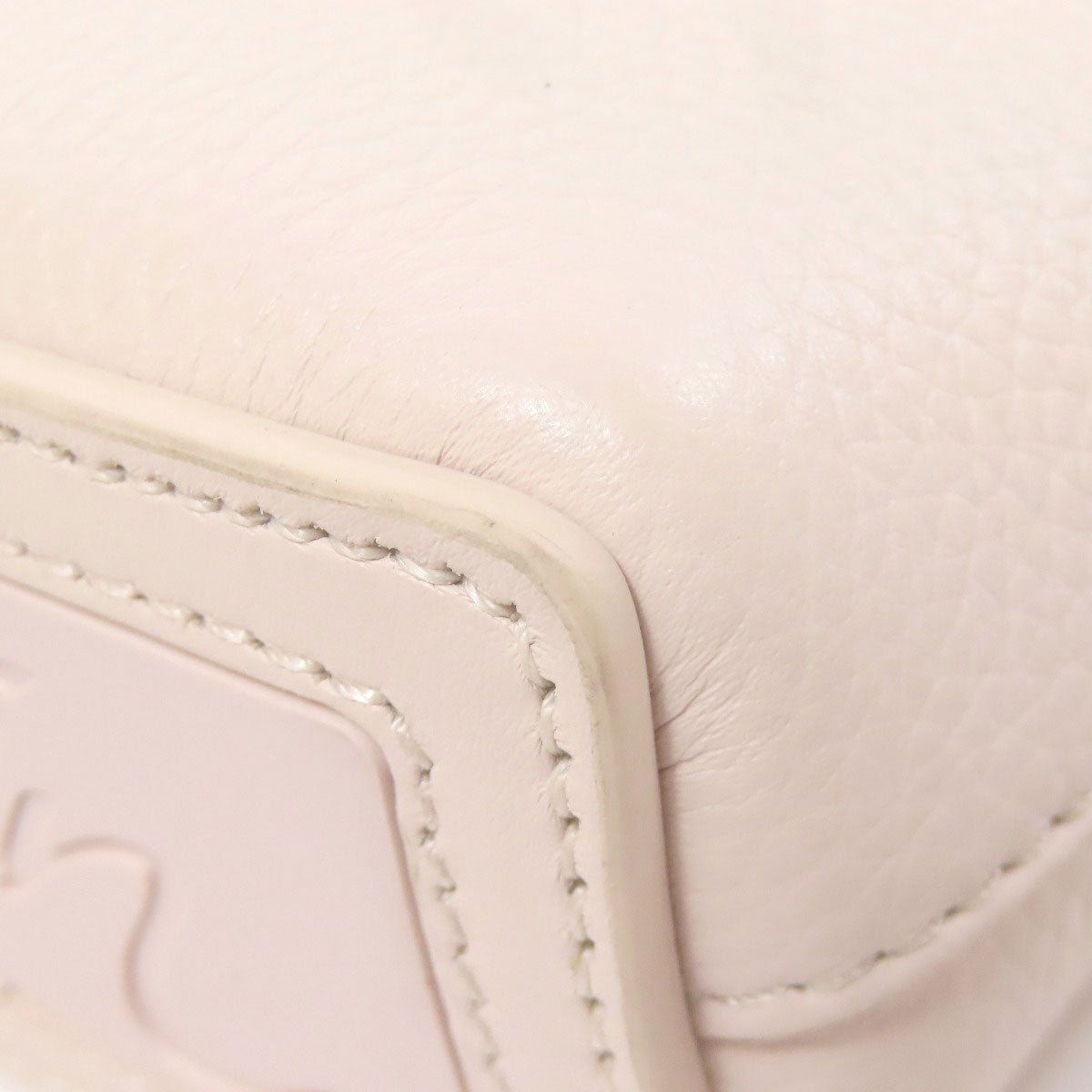 Close-up of a light pink leather product with visible stitching