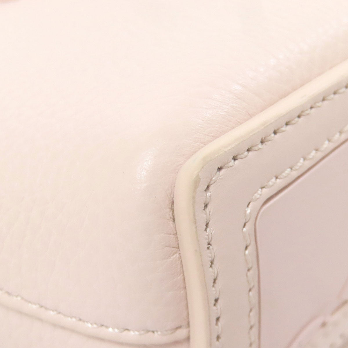 Close-up of a light pink leather product with visible stitching