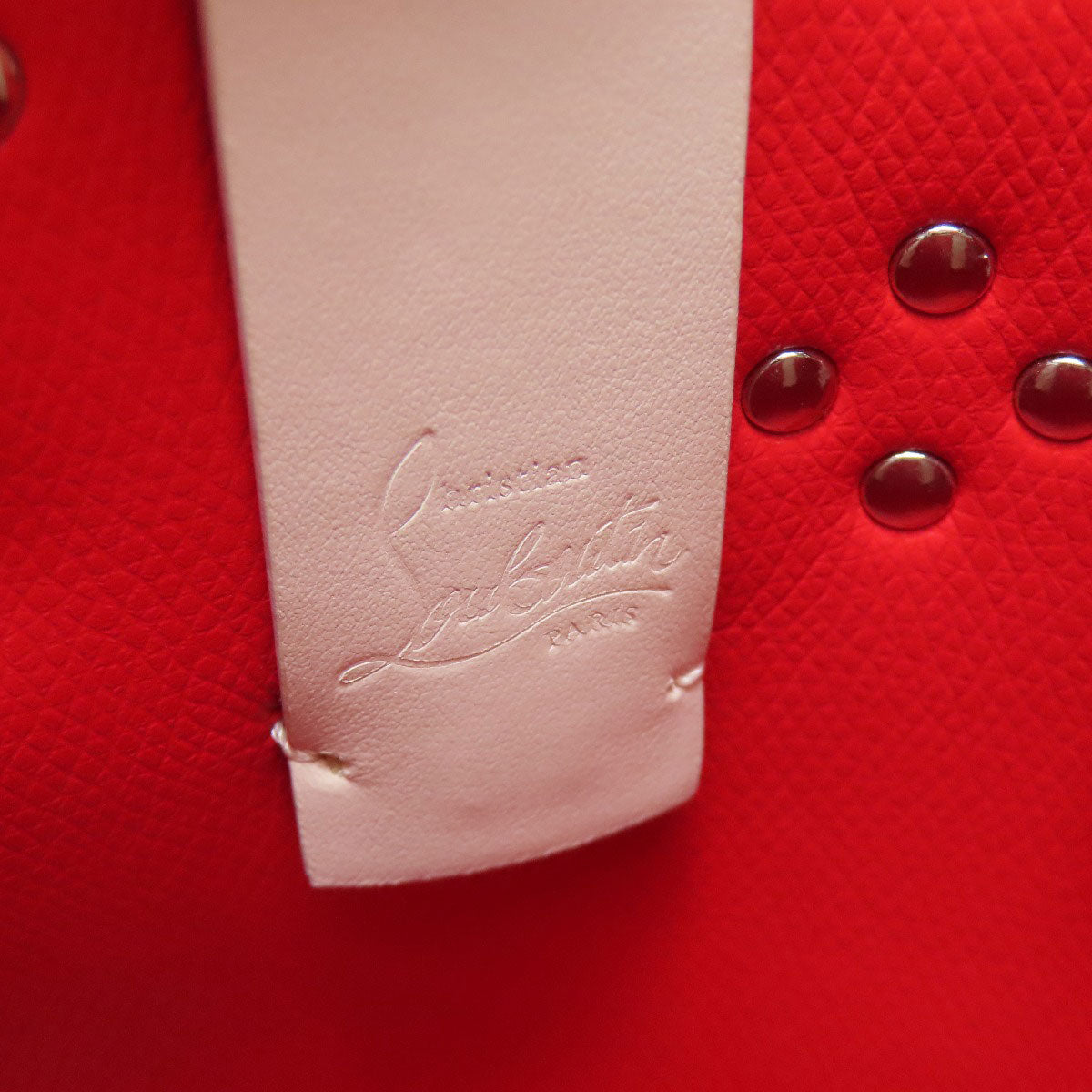 Close-up of a red textured surface with a white label and silver buttons.