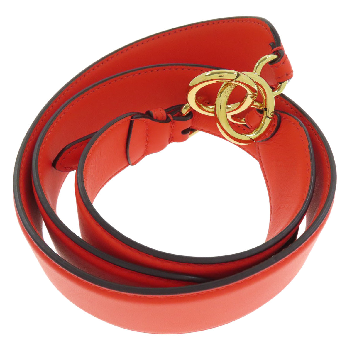 Red leather belt with gold hardware on a white background