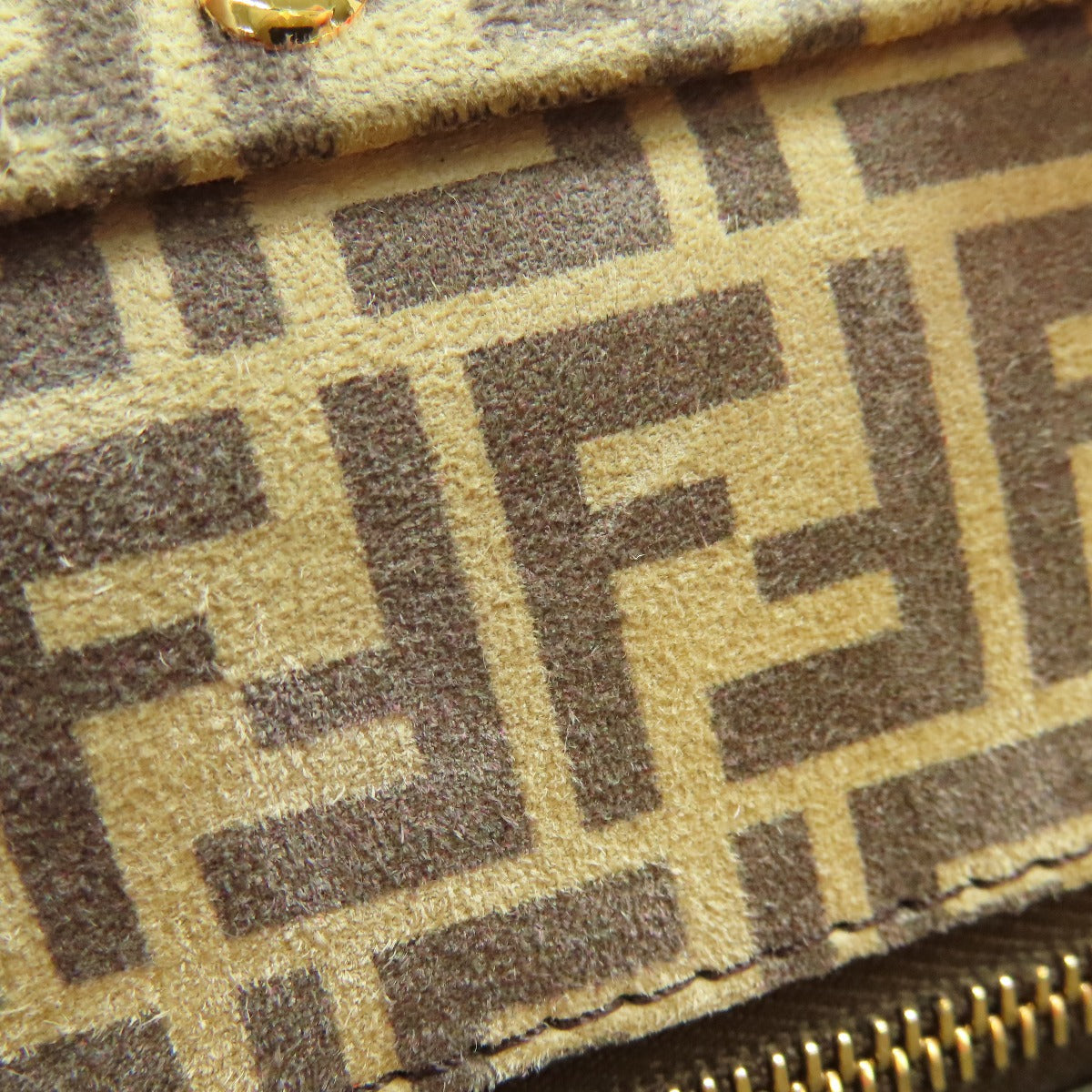 Close-up of a patterned fabric with a distinctive logo, likely from a high-end brand.
