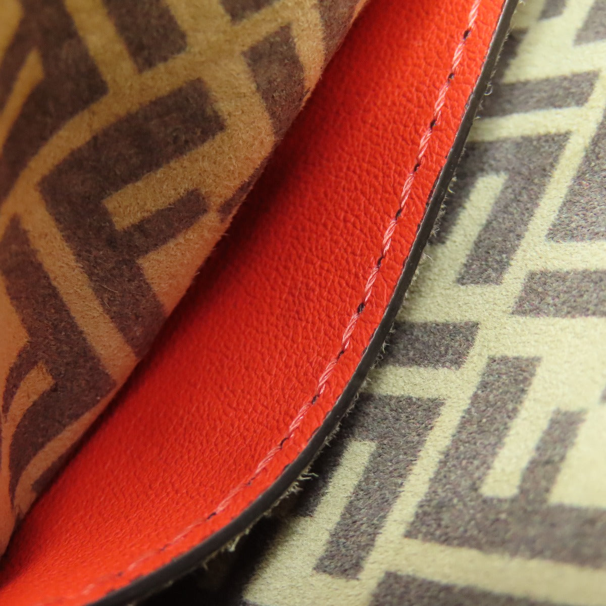 Close-up of red leather with brown patterned fabric in the background