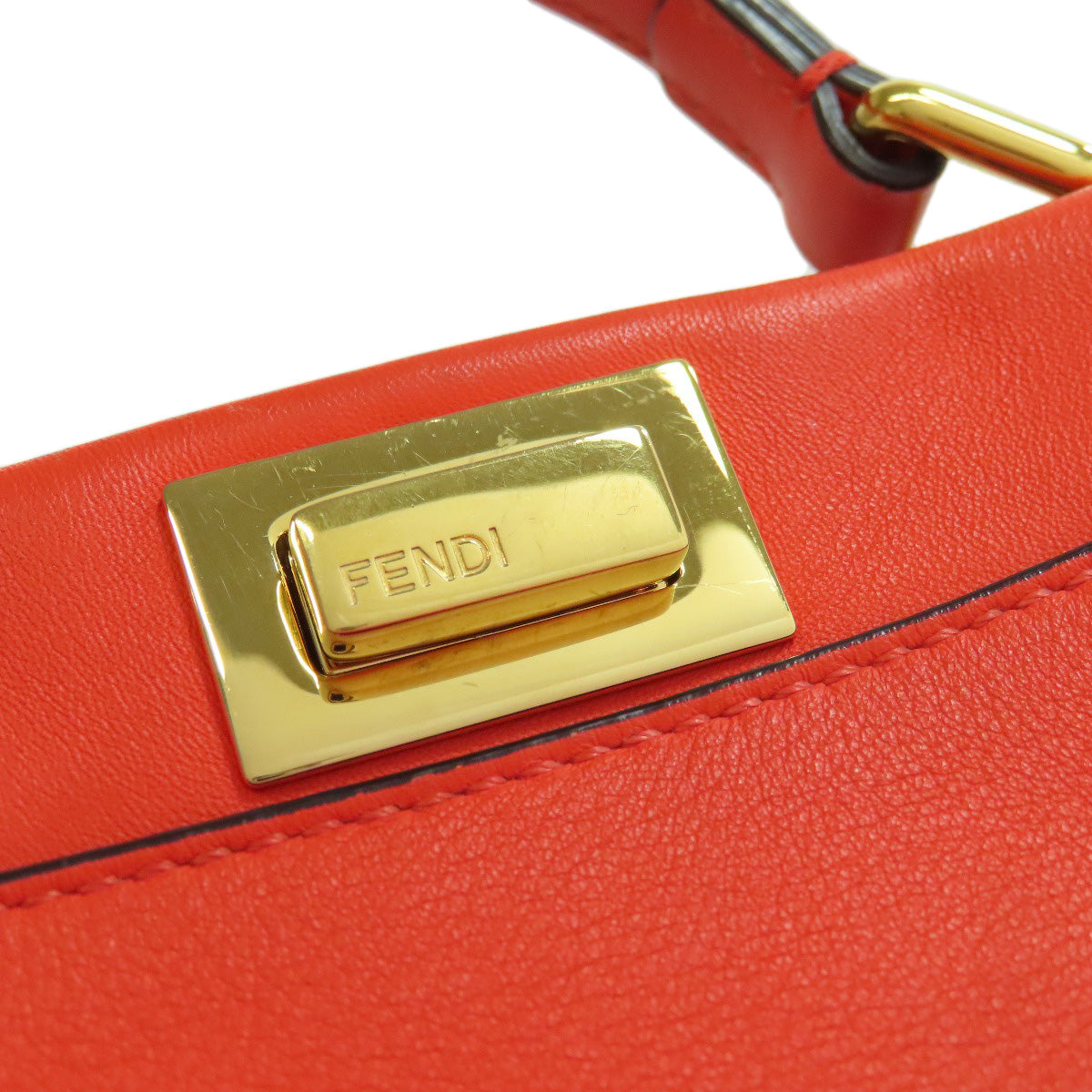 Red handbag with gold Fendi clasp on a white background