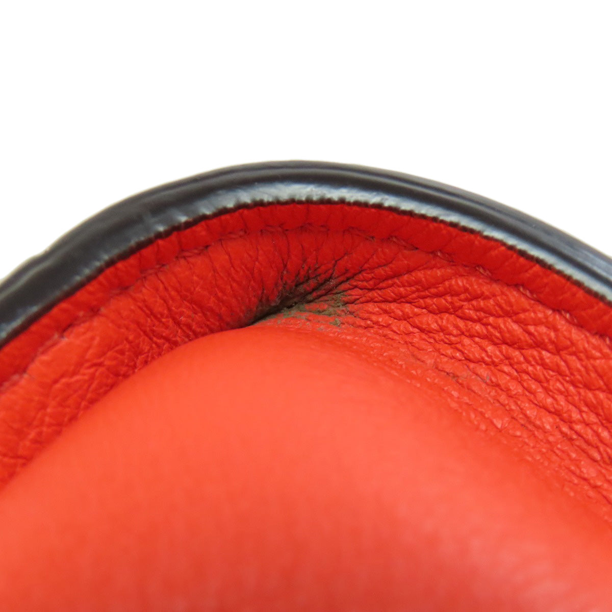 Close-up of a red leather product with a black interior on a white background