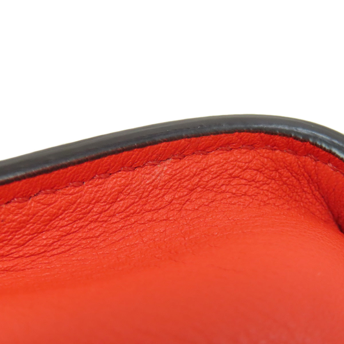 Close-up of a red leather surface with a black border on a white background
