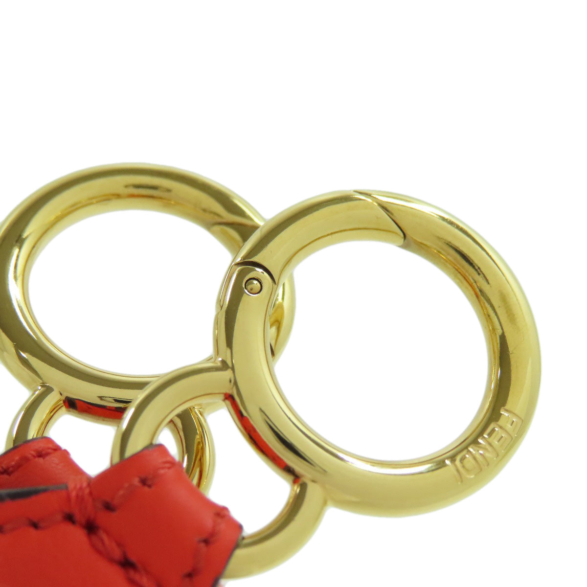 Gold keychain with red paw-shaped charm on a white background