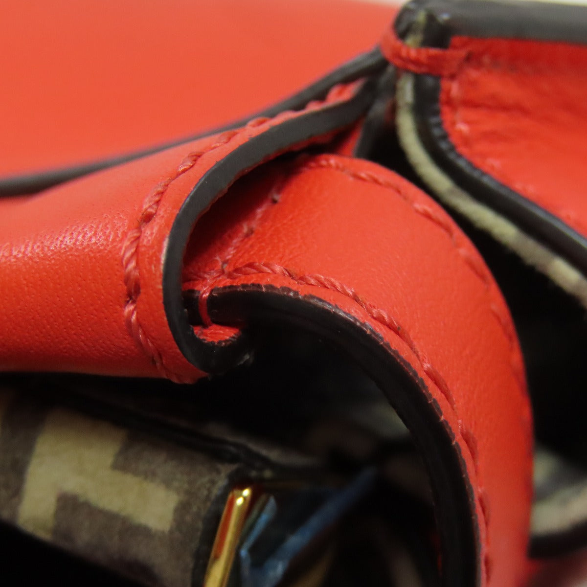 Close-up of red leather product with visible stitching