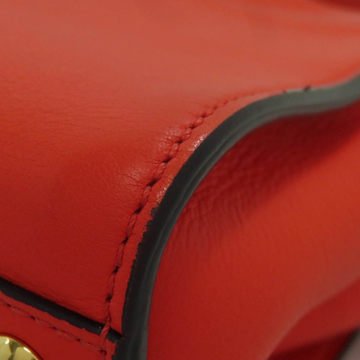 Close-up of a red leather product with stitching detail