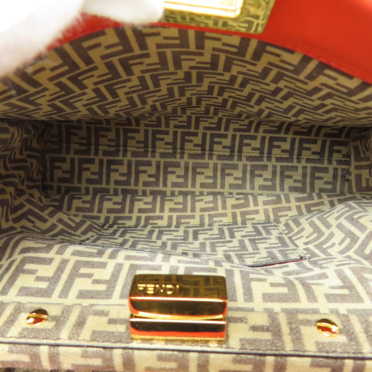 Close-up of a patterned bag interior with a gold clasp.