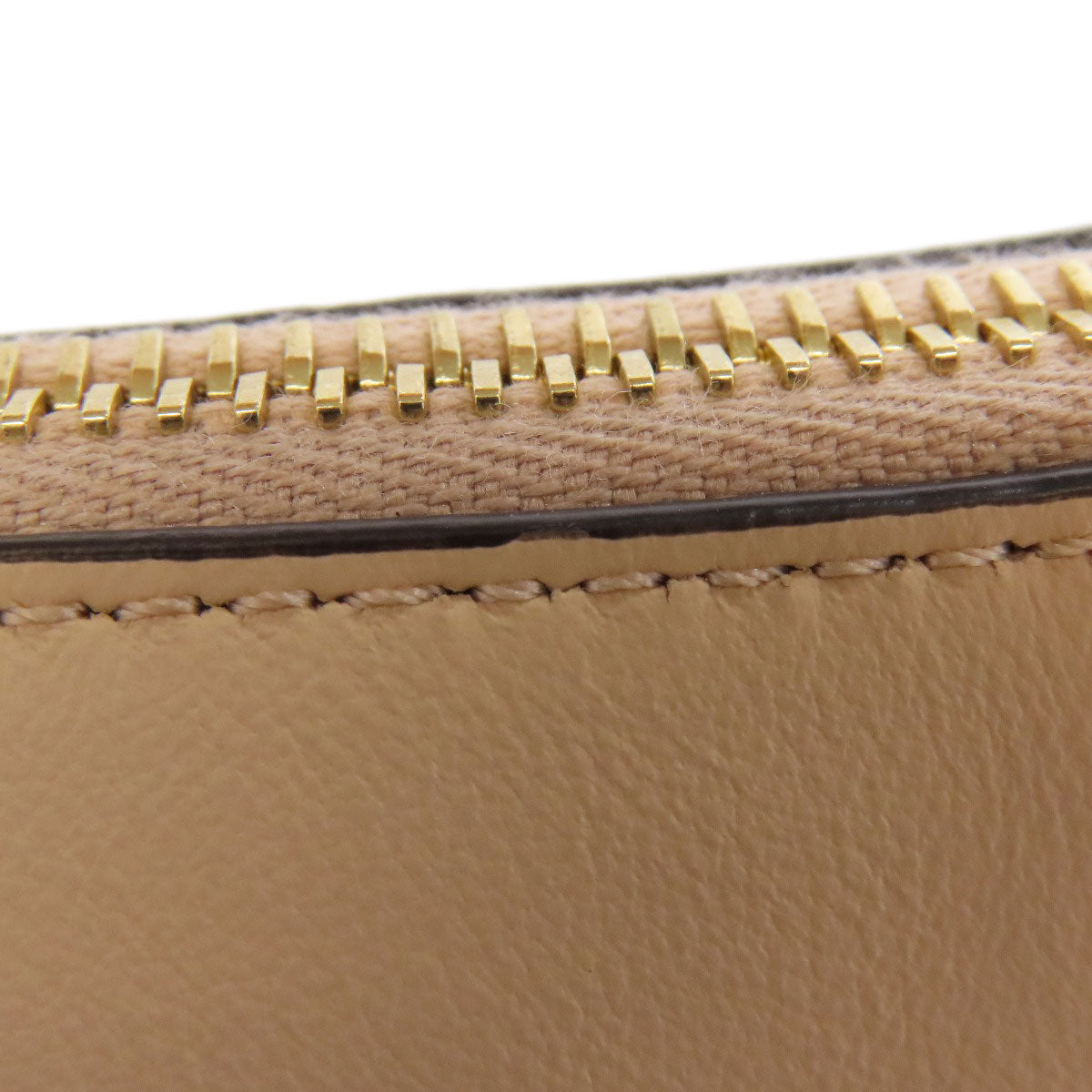 Close-up of a beige leather wallet with gold zipper details on a white background