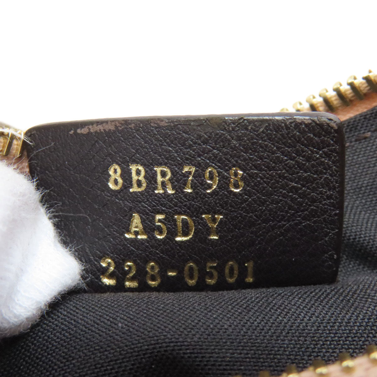 Close-up of a leather tag with gold text on a black background