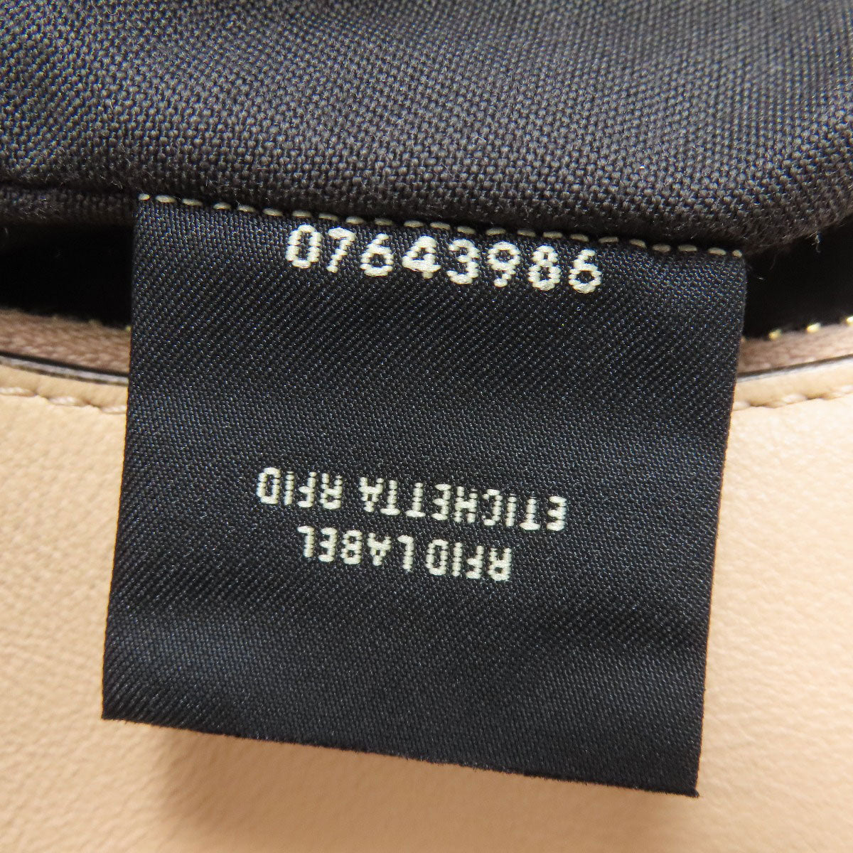 Clothing label with text and number on a fabric background