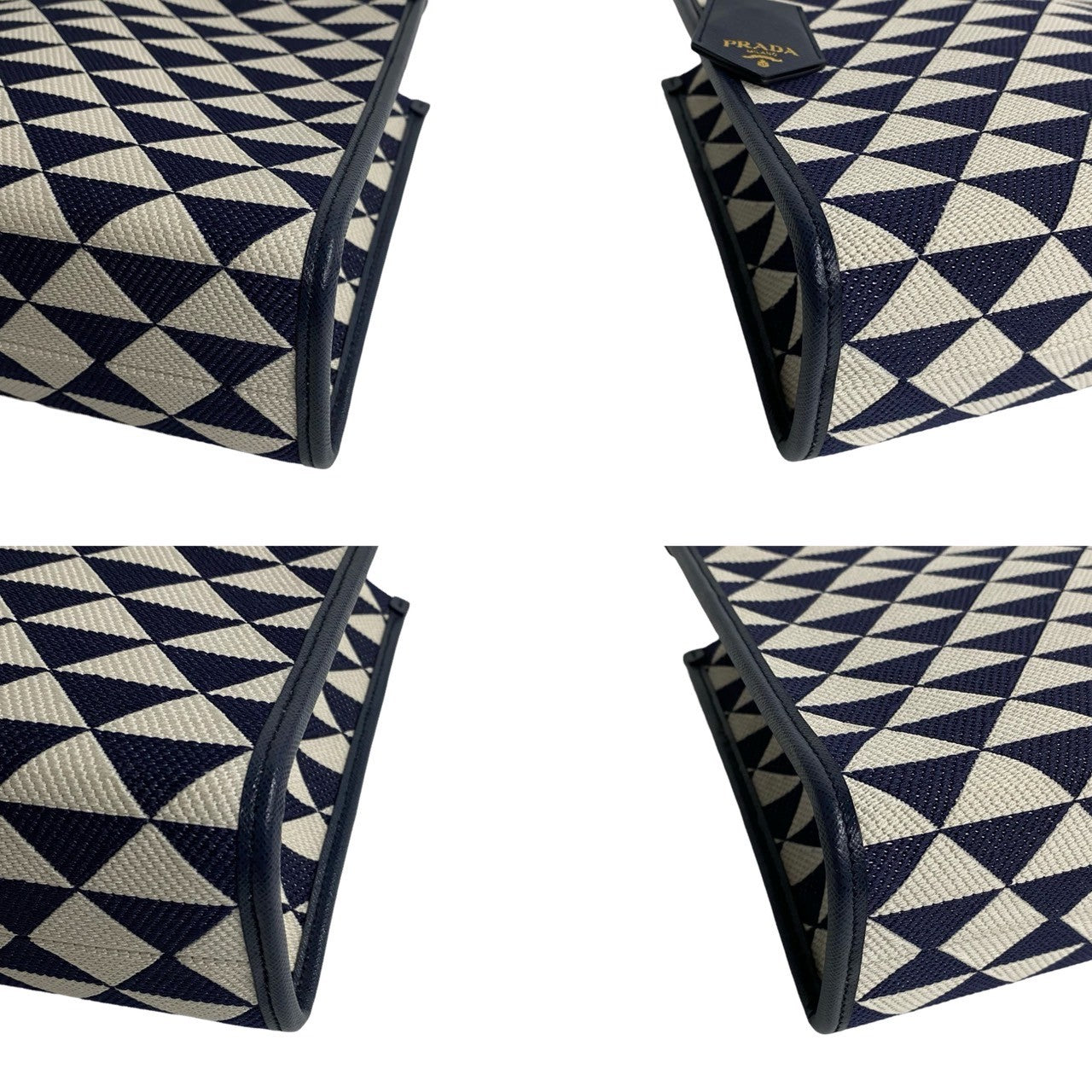 Navy and white geometric patterned clutch bag with Prada logo.
