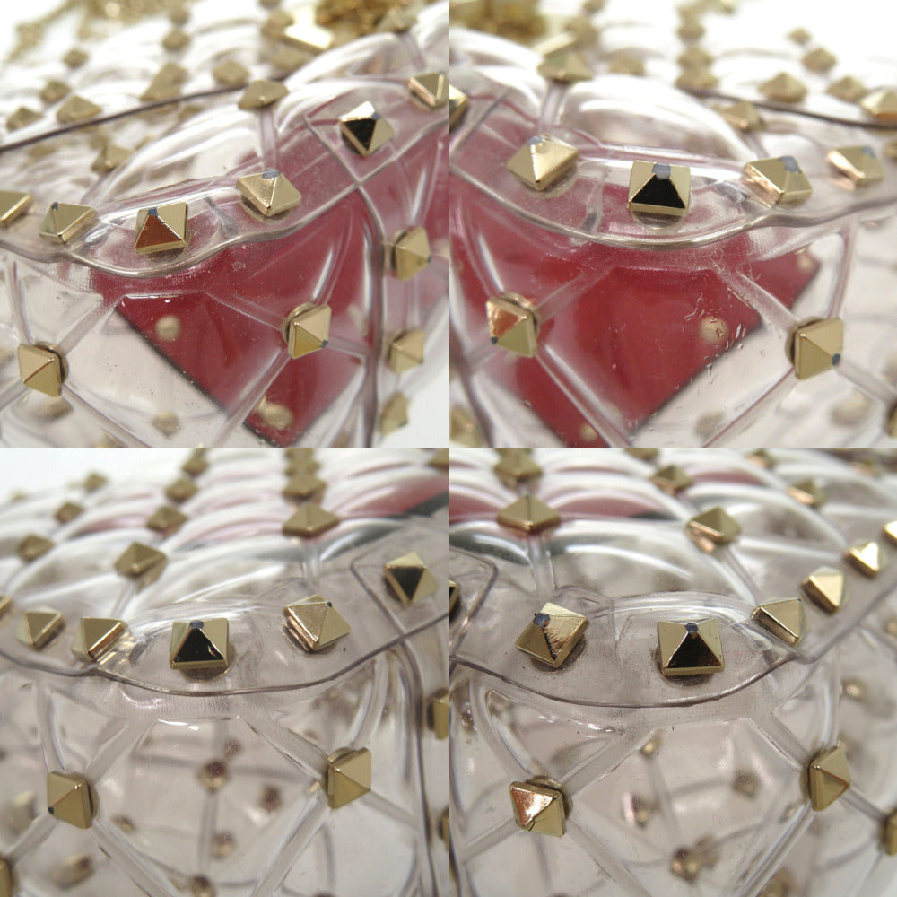 Clear lip balm with gold and black pyramid studs on a white background