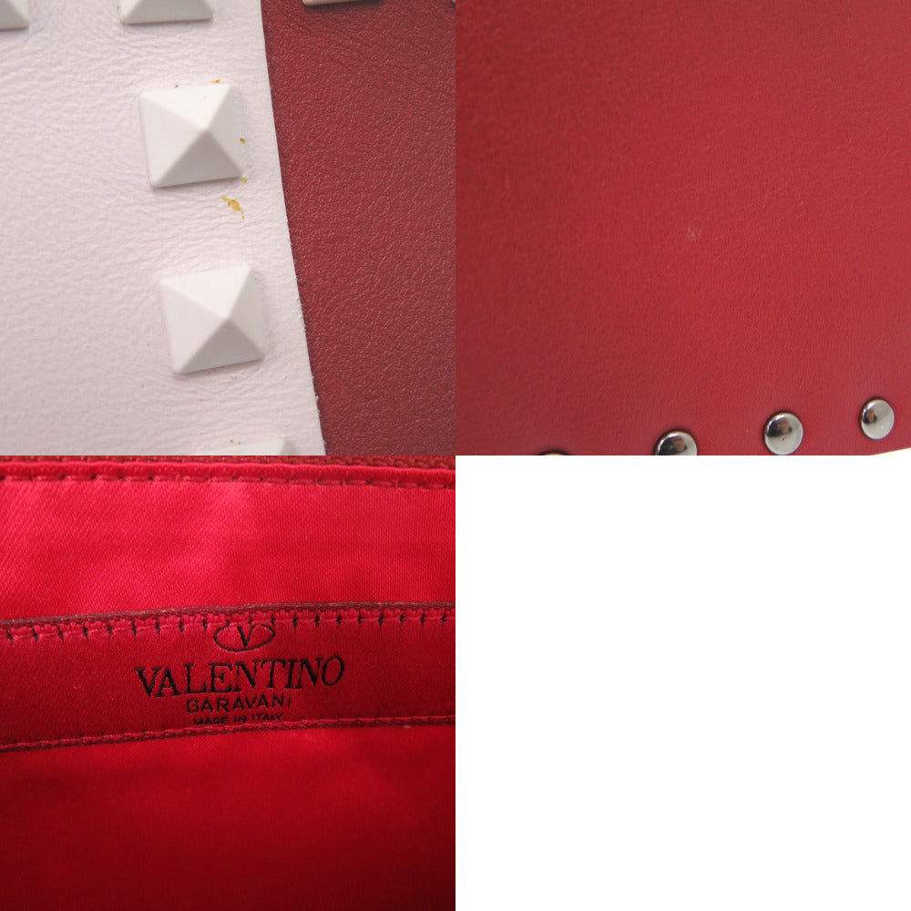 Close-up of a red leather product with 'Valentino' branding, featuring studs.