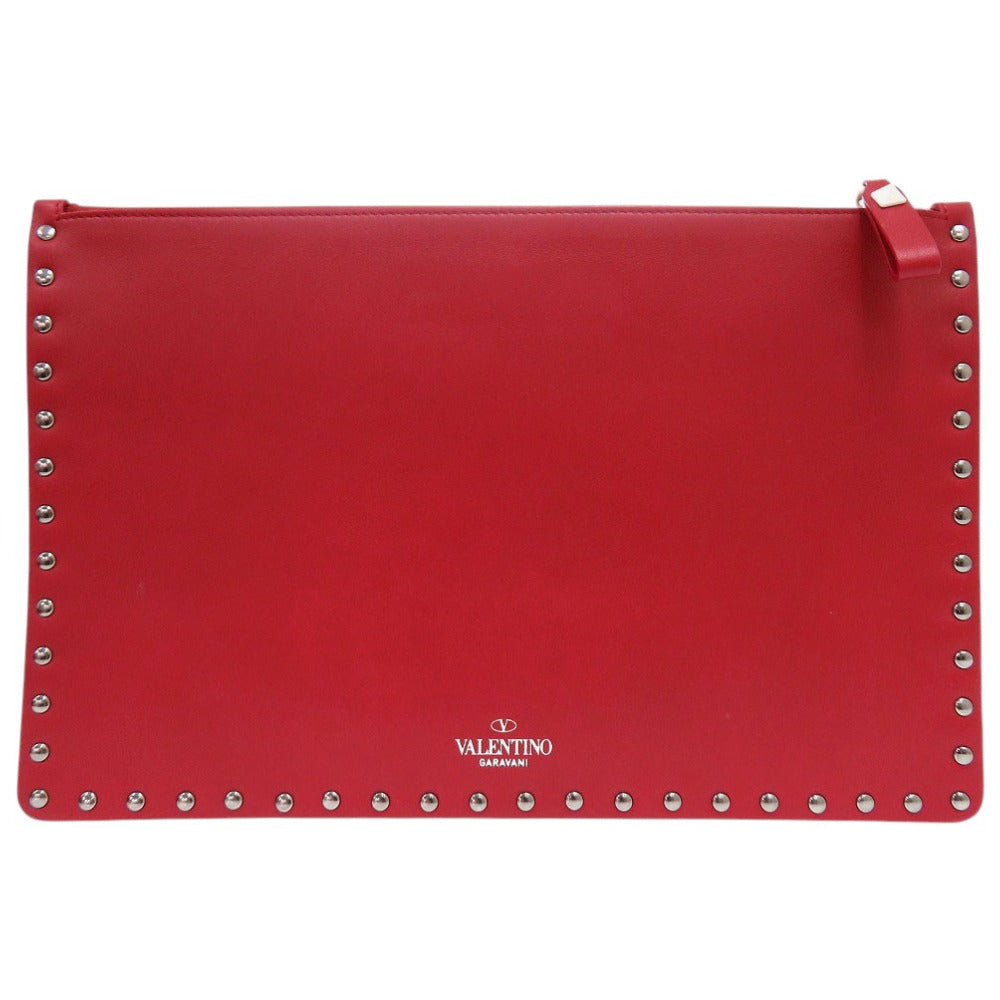 Red clutch bag with studded details on a white background, featuring the Valentino logo.