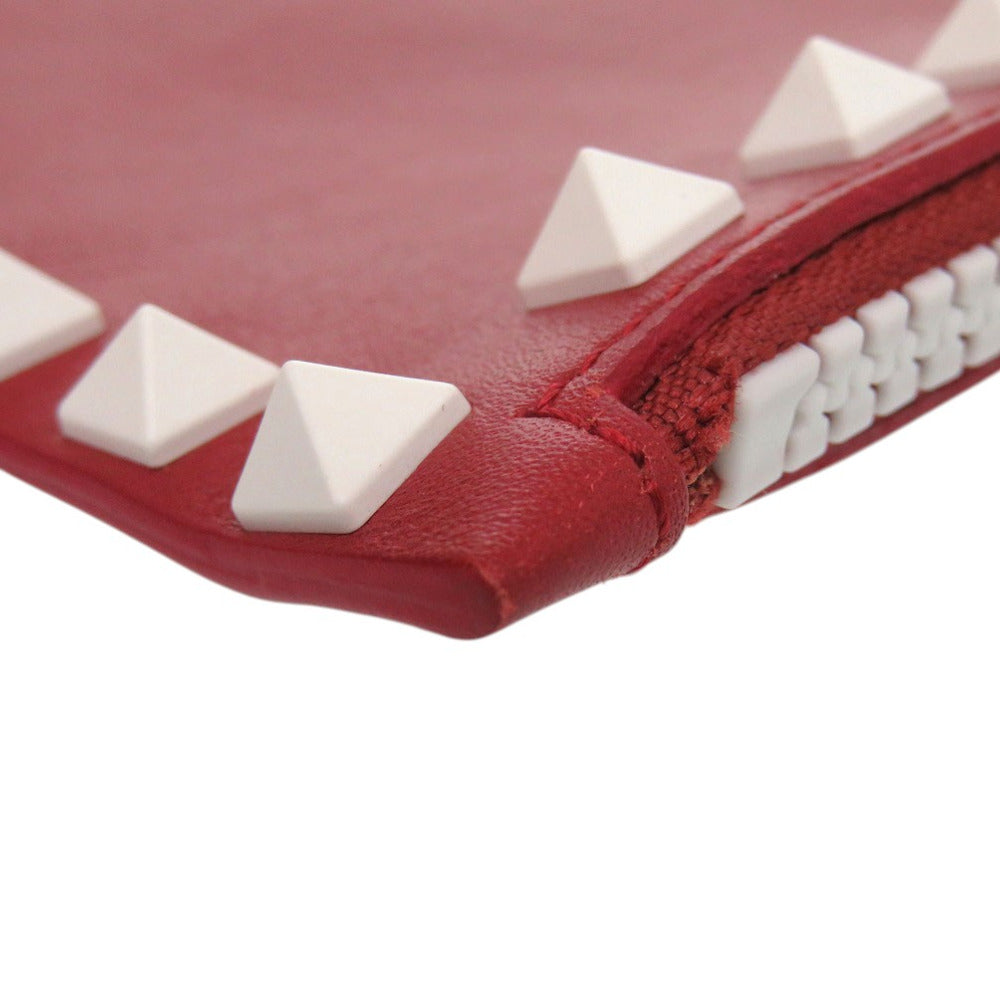 Red wallet with white pyramid studs on a white background
