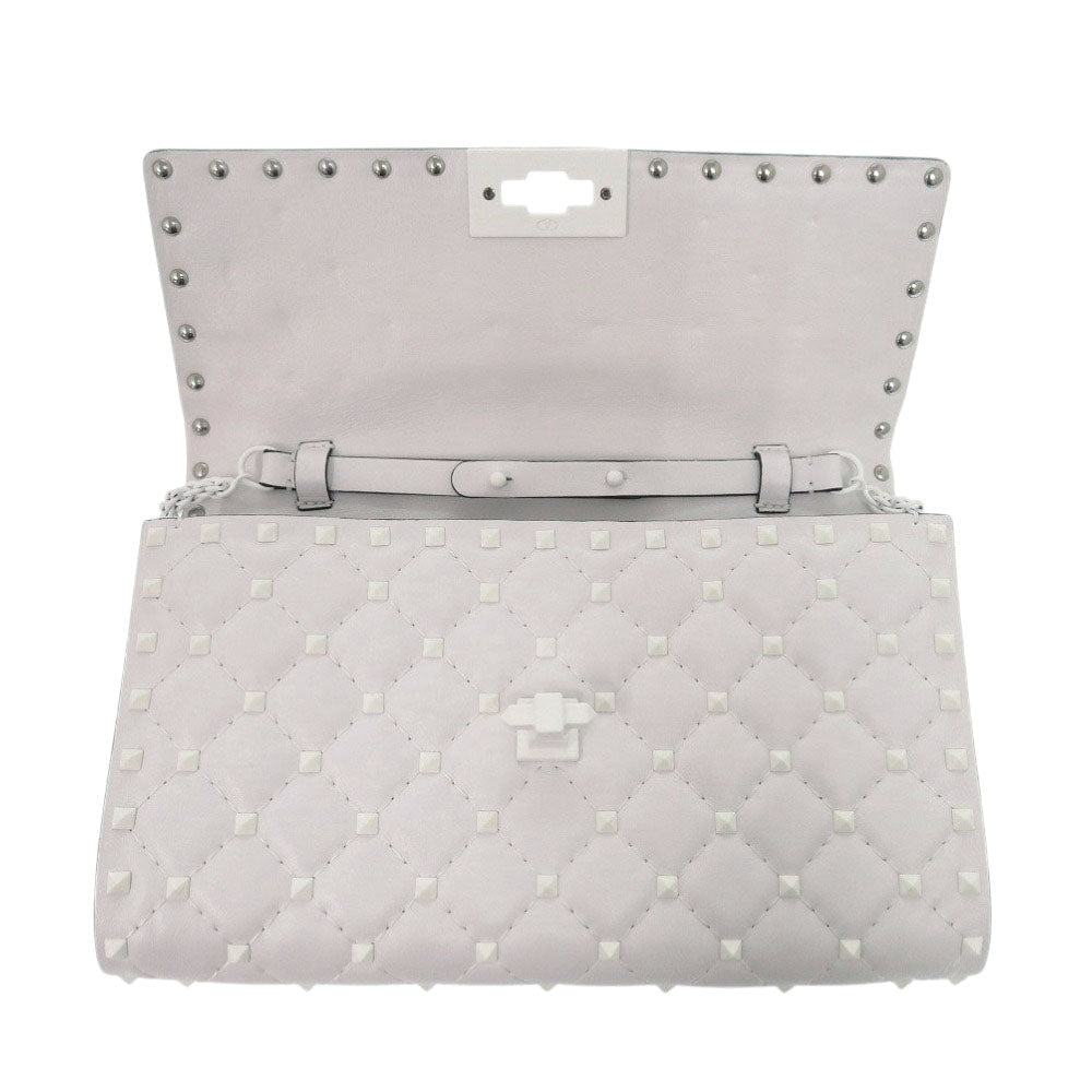 Quilted gray handbag with studded details on a white background