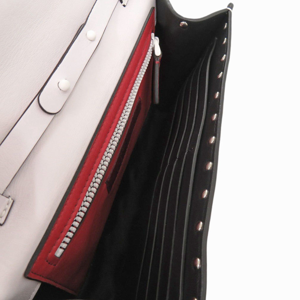Close-up of a handbag with a red interior and black exterior.