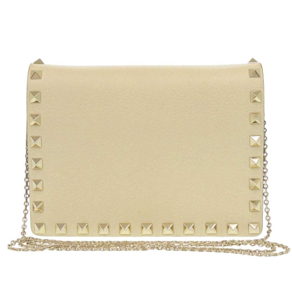 Beige clutch bag with gold studs on a white background