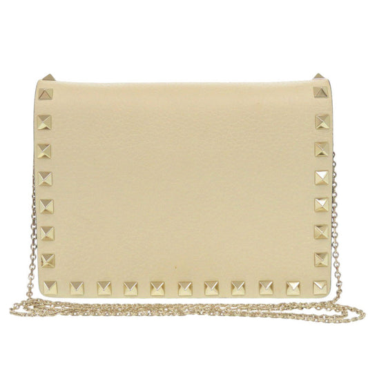 Beige clutch bag with gold studs on a white background