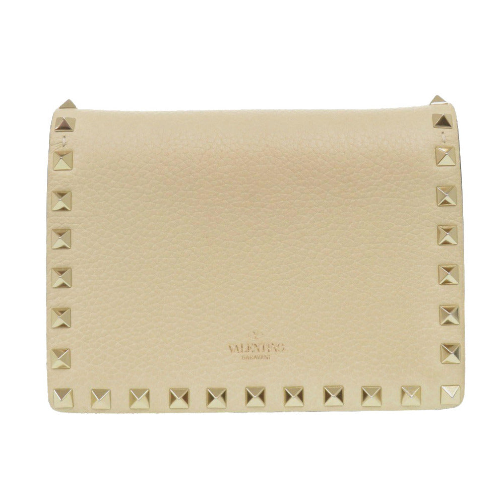 Beige handbag with studded details on a white background