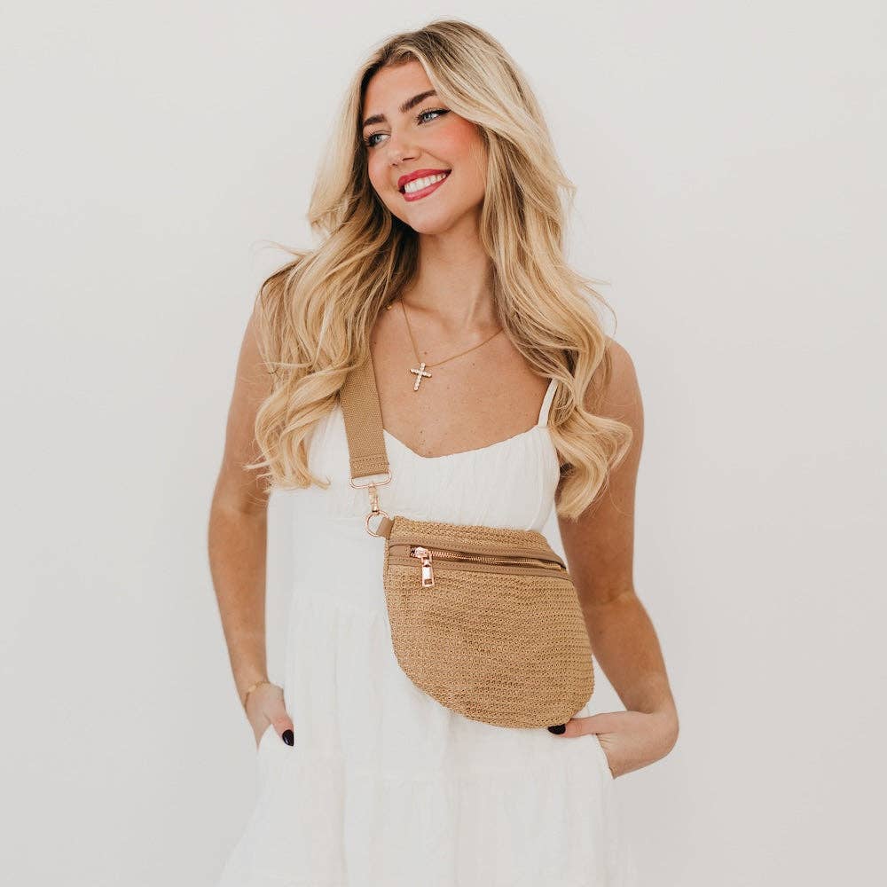 Woman wearing a beige waist bag against a plain background