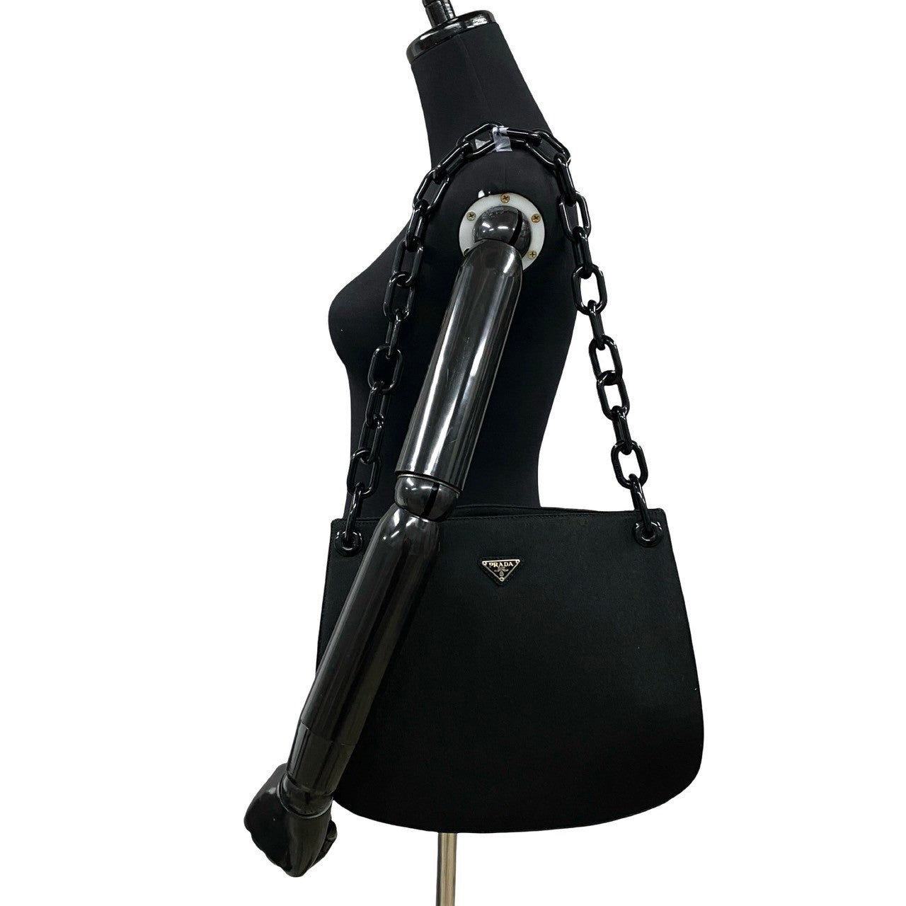 Black handbag with chain detail on a mannequin against a white background