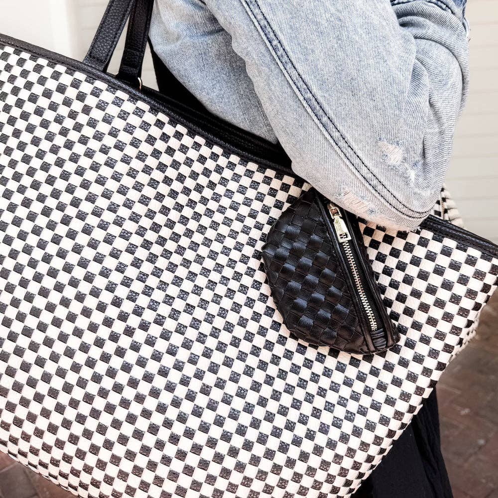 Black and white checkered bag with a black pouch on top, next to a denim jacket.