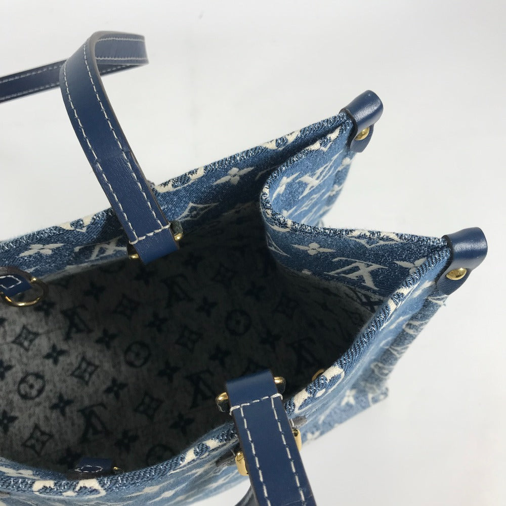 Blue denim handbag with gold accents on a white background