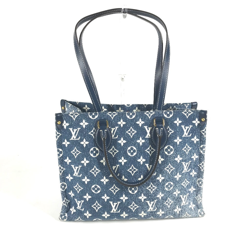Blue handbag with white monogram pattern on a white background
