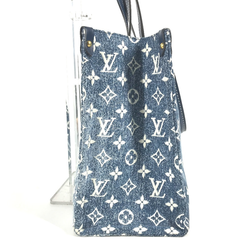 Blue denim handbag with white monogram pattern on a white background