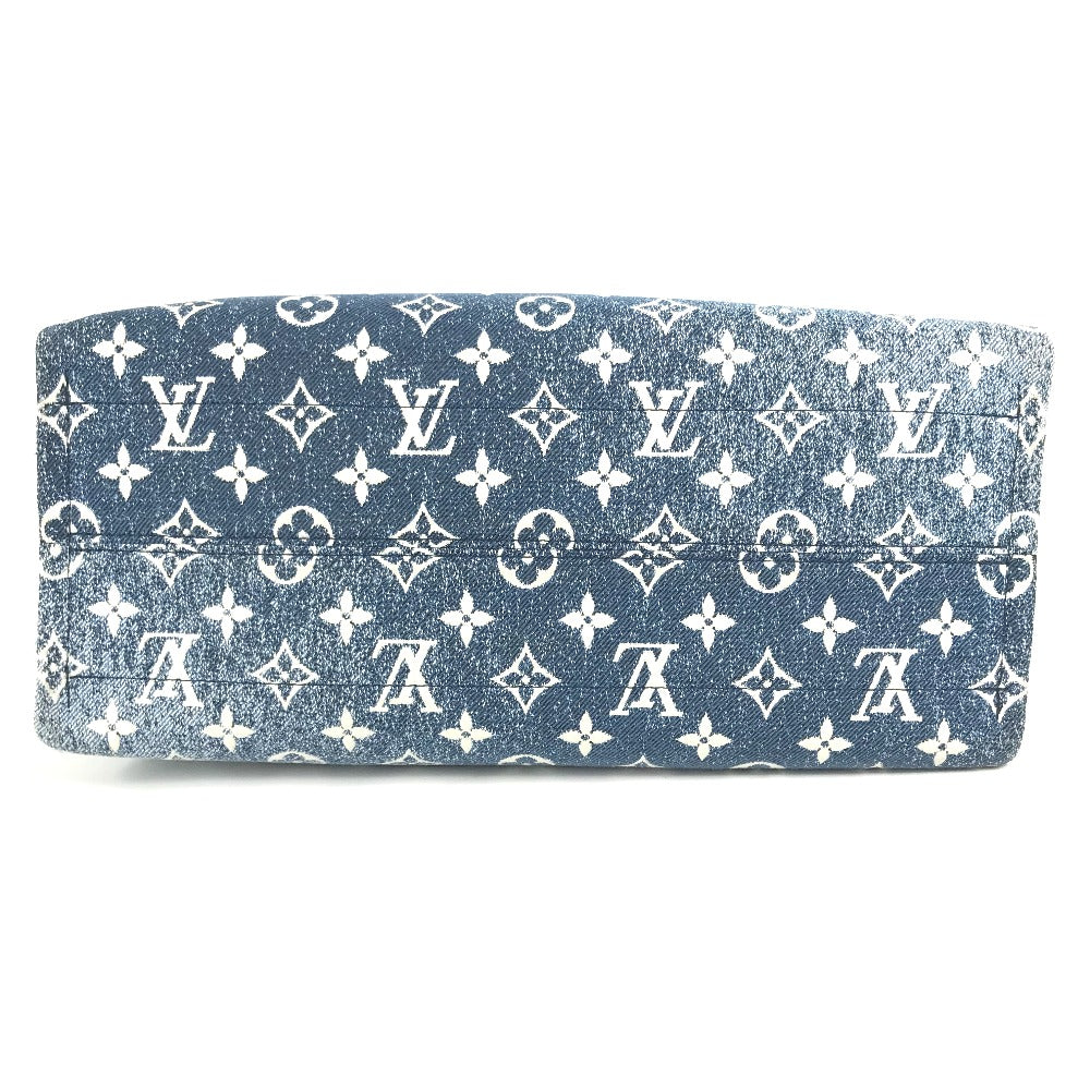 Blue clutch bag with white monogram pattern on a white background