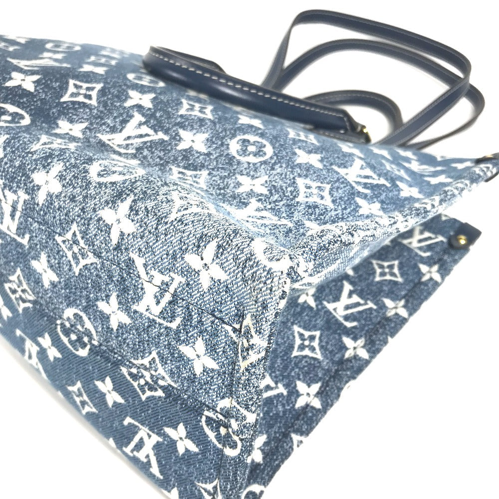 Blue monogrammed fabric with a black handle on a white background