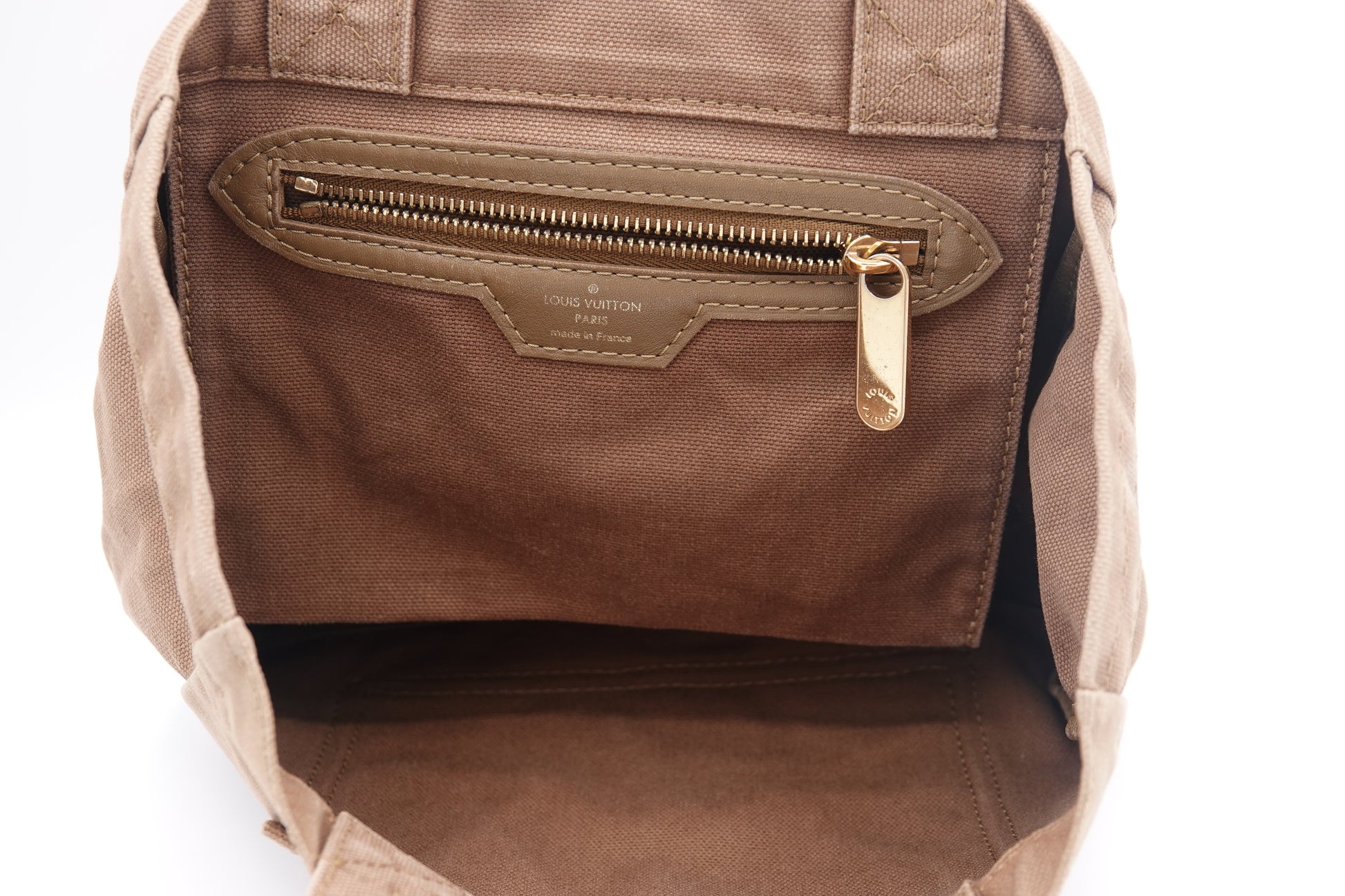 Brown leather bag with gold zipper on a white background