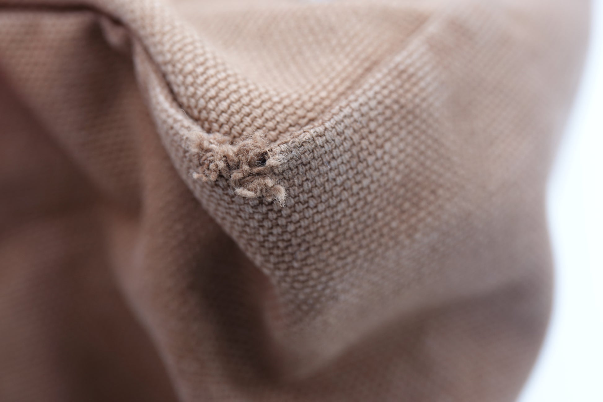 Close-up of brown fabric with visible wear and tear.