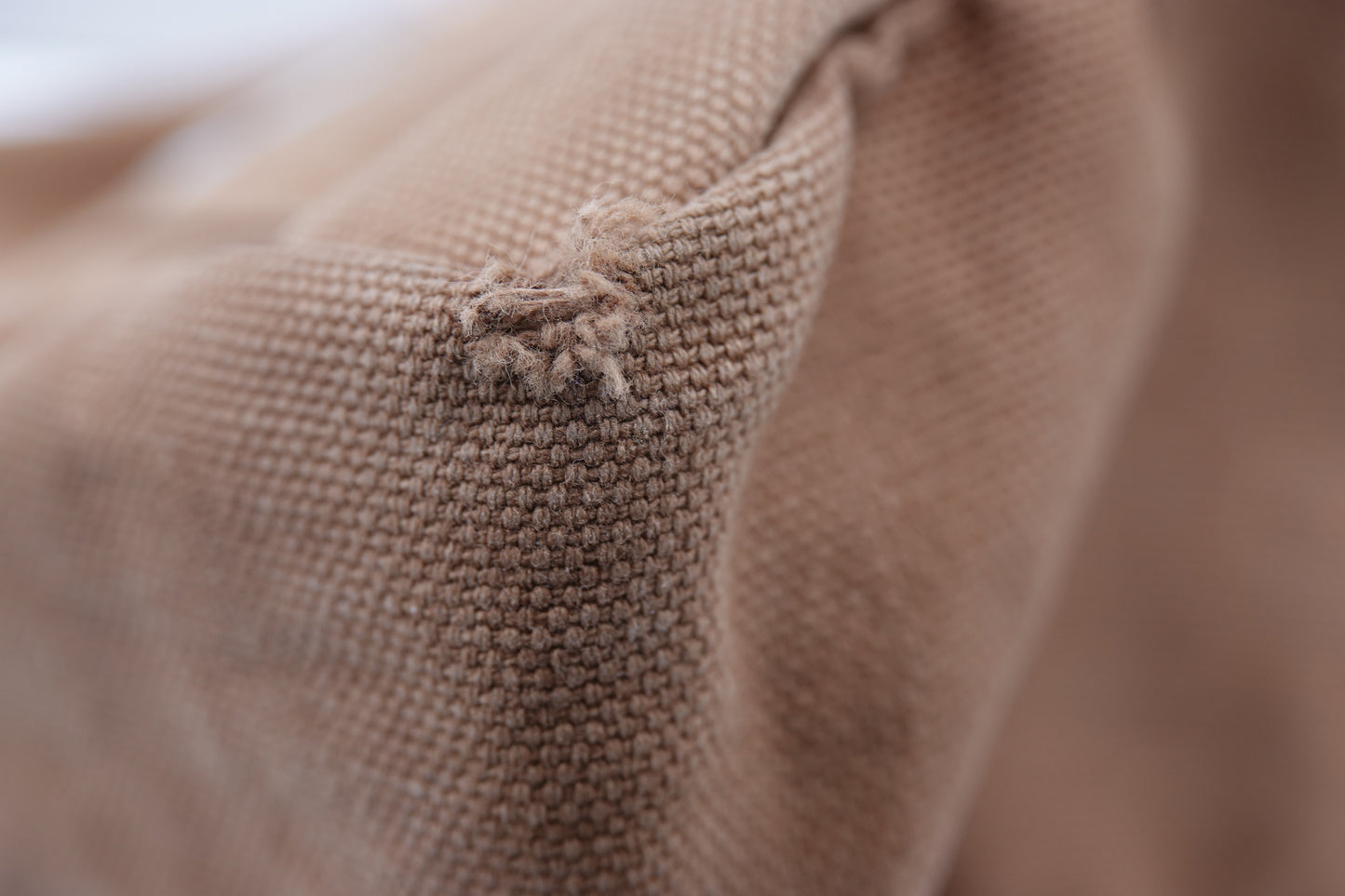 Close-up of brown fabric with a brand logo.